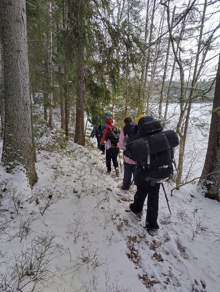 Partiolaisia retkeilemässä talvella metsässä.